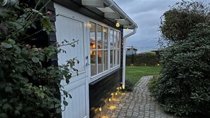 Una casa con fachada blanca, un sendero pavimentado y una siega bien cuidada.