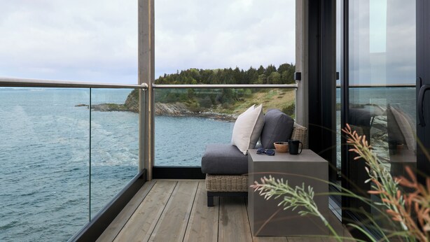 A balcony with a view of the sea and a forested hill. - Hideaway Herdla 1 – unique and luxurious cabin 15 m above the sea near Bergen (Herdla)