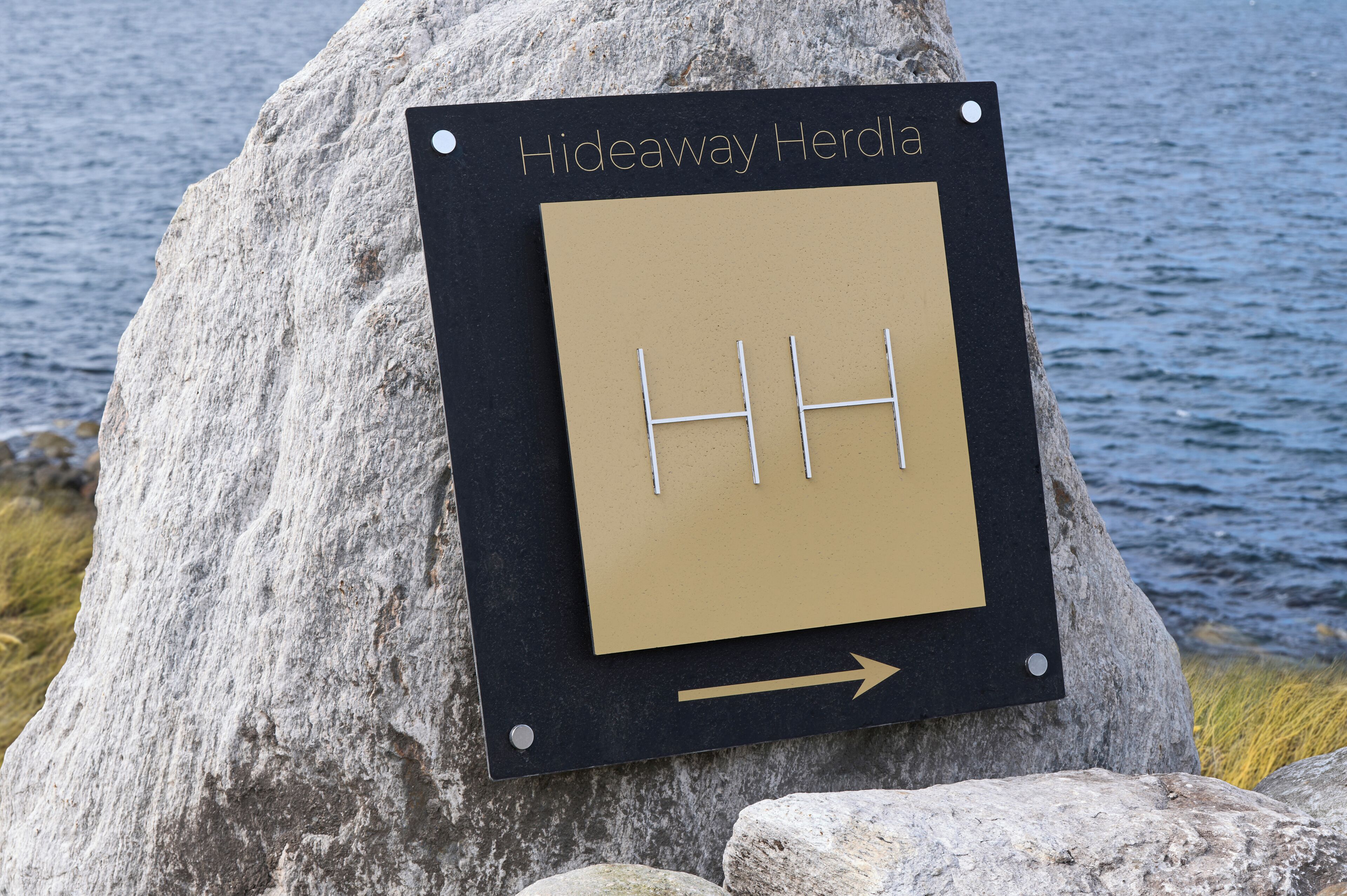 Un panneau indiquant « Hideaway Herdla » et une flèche pointant vers la droite.
