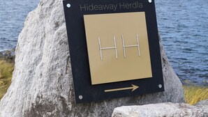 Un panneau indiquant « Hideaway Herdla » et une flèche pointant vers la droite.