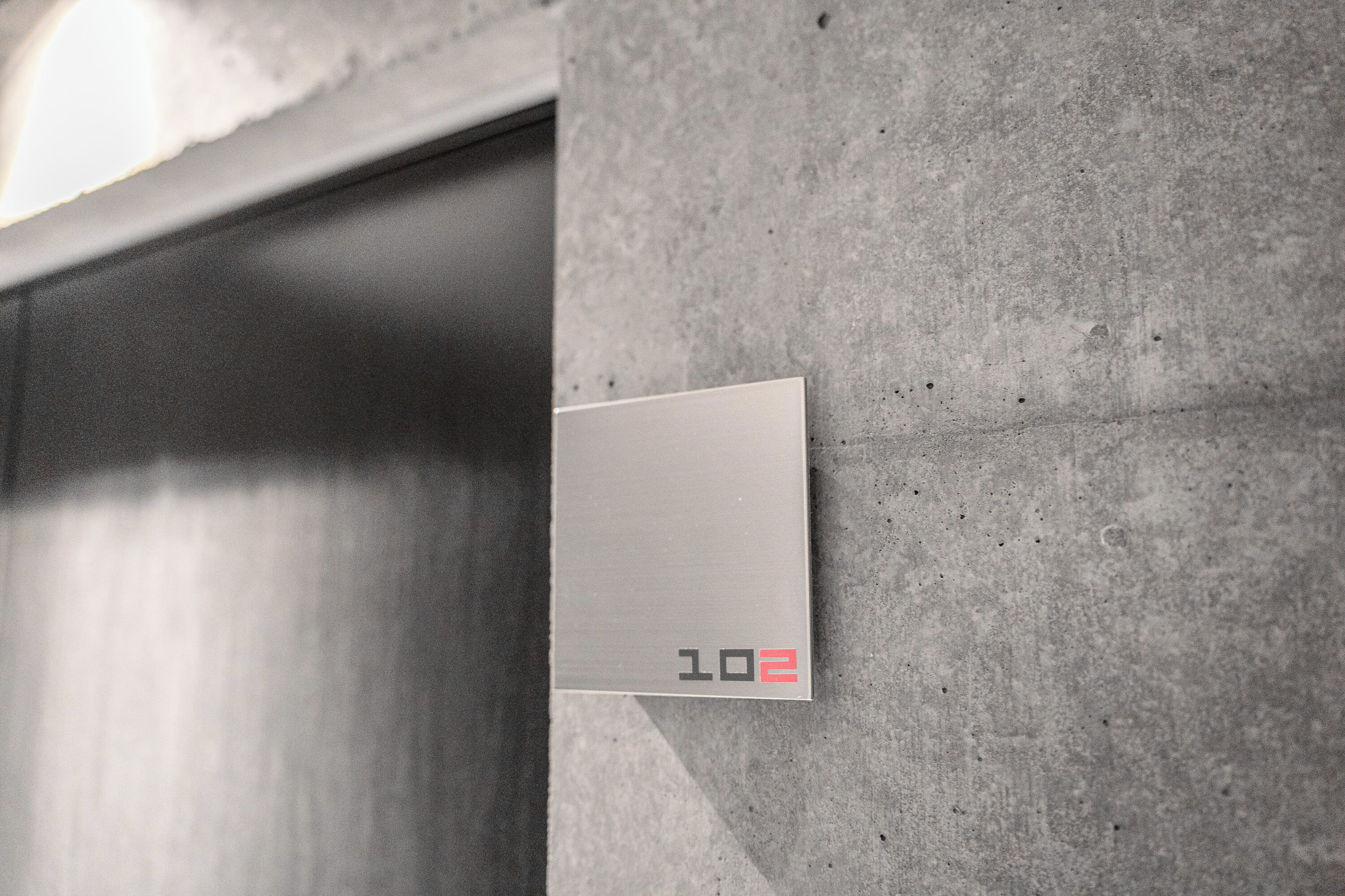 A metallic elevator door with a sign displaying the number "102".