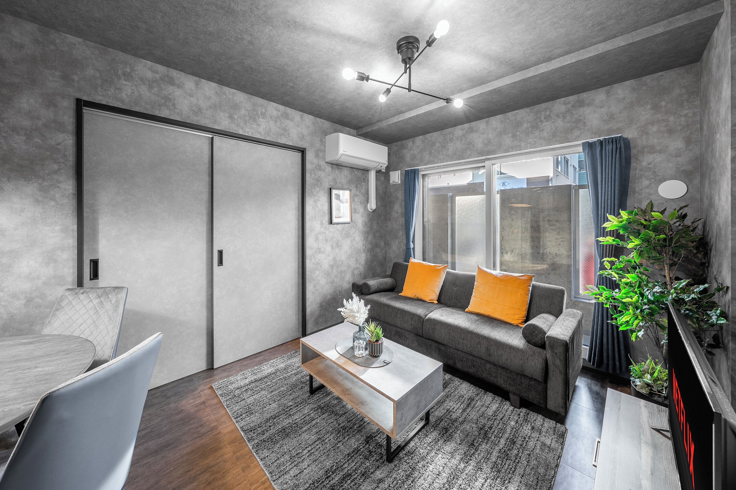 Ein modernes Wohnzimmer mit grauem Sofa, einem Couchtisch und einem TV-Schrank.