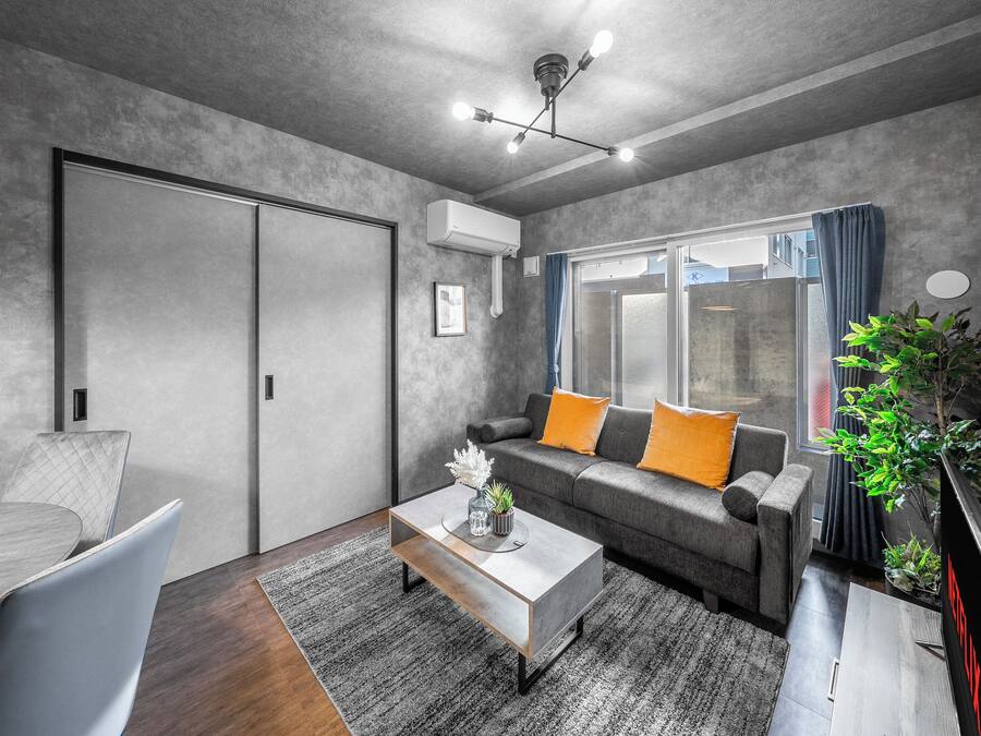 Een moderne woonkamer met een grijze bank, een salontafel en een tv-meubel.