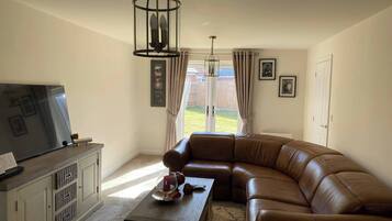 Hus, 3 soverom, hageutsikt | Oppholdsrom | Flatskjerm-TV og bøker