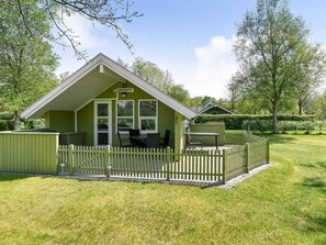 A green building with a white picket fence, a covered patio with chairs, and a sign reading "EKKALDHYT". - 5 Star Holiday Home in Grindsted (Grindsted)