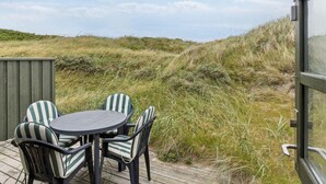 Un espace extérieur aménagé avec une table ronde et des chaises, offrant une vue sur un paysage verdoyant.