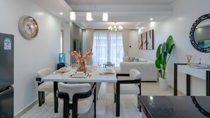 Ein modernes Wohnzimmer mit Essbereich, einem großen Spiegel und einer Kronleuchter.