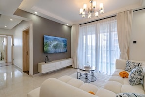 Departamento clásico, balcón, vista a la ciudad | Área de sala de estar | Televisión de plasma de 55 pulgadas con canales por cable y Netflix