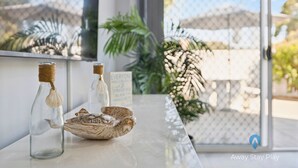Une table sur laquelle se trouvent deux bouteilles en verre et une sculpture d’oiseau décorative.