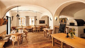 En hyggelig restaurant med træmøbler, hvælvede lofter og en menu på tavle.