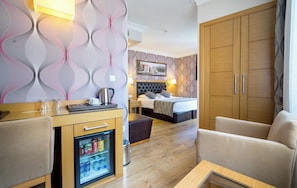 A hotel room with a bed, a desk with a refrigerator, a sofa, and a wardrobe. - Levent Hotel Istanbul (Istanbul)