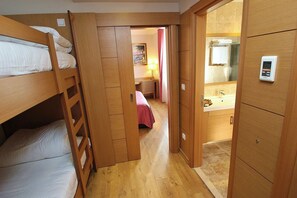 A narrow hallway with wooden bunk beds on one side and a bathroom with a shower and a towel rack on the other. - Levent Hotel Istanbul (Istanbul)