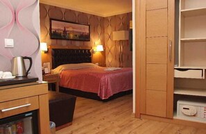 A hotel room with a bed, bedside lamps, a coffee maker, a refrigerator, and a wall-mounted picture. - Levent Hotel Istanbul (Istanbul)