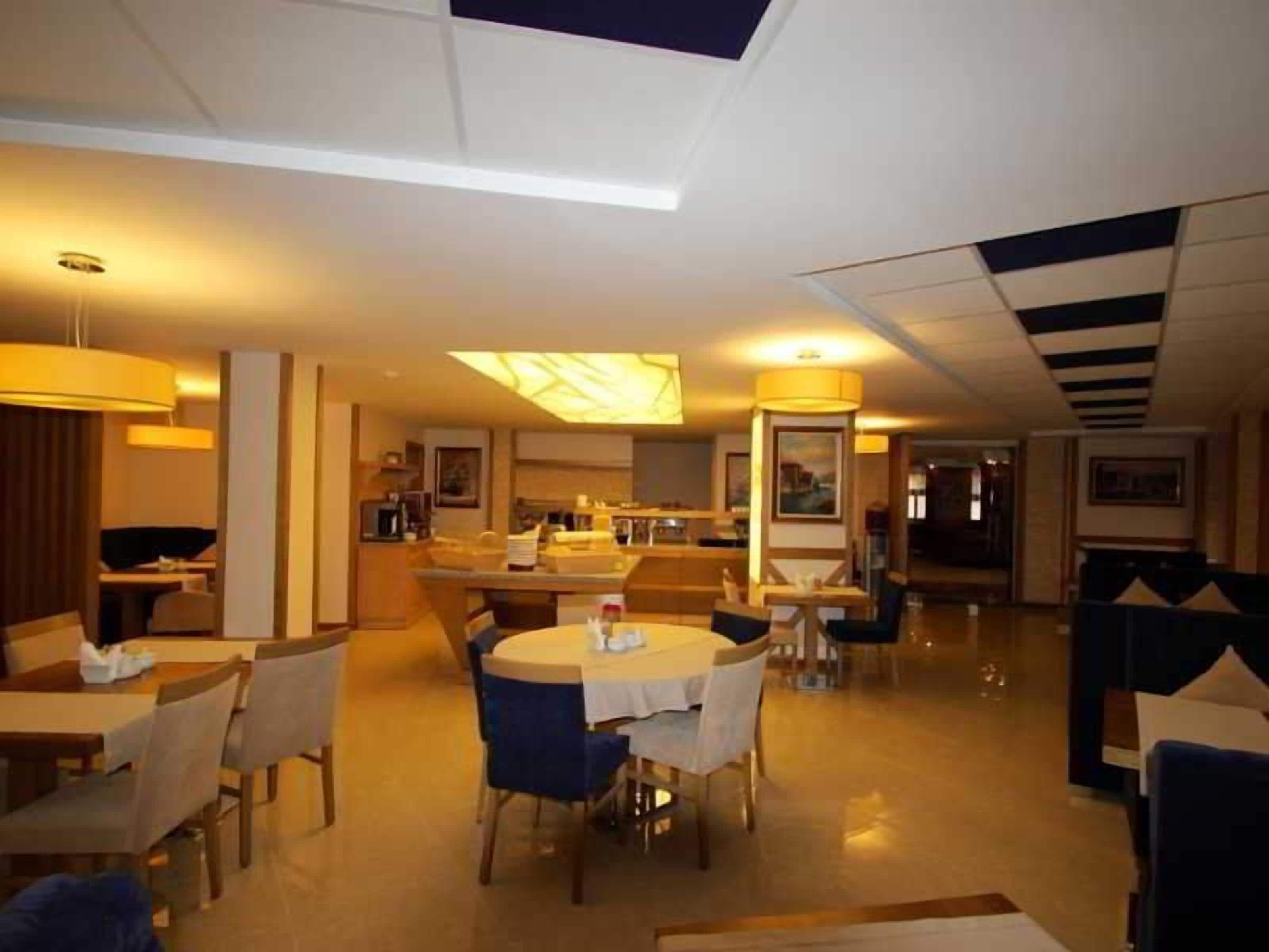 A hotel lobby with a dining area, a bar, and a reception desk.