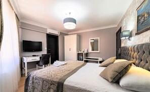 Ein Hotelzimmer mit einem Bett, einem Schreibtisch, einem Fernseher, einem Kleiderschrank und einem Spiegel.
