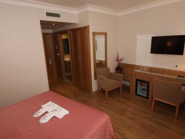A hotel room with a bed, a desk, a chair, a television, and a bathroom. - Levent Hotel Istanbul (Istanbul)