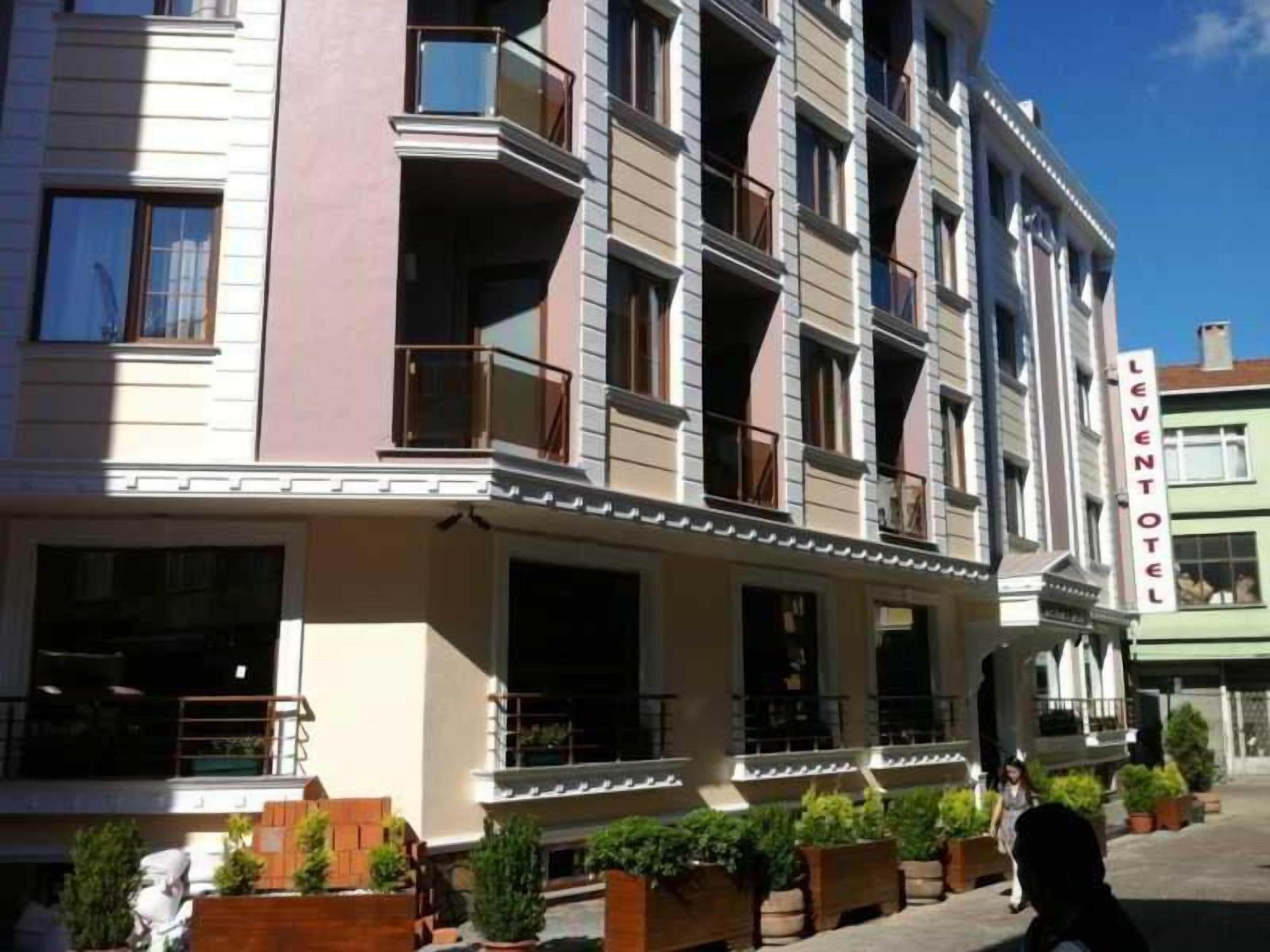 Ett hotell med flera våningar, balkonger, en tydligt markerad entré och en skylt med texten ”LEVENTOTEL”.