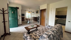 A compact living space with a dining area, kitchenette, and a sofa.
