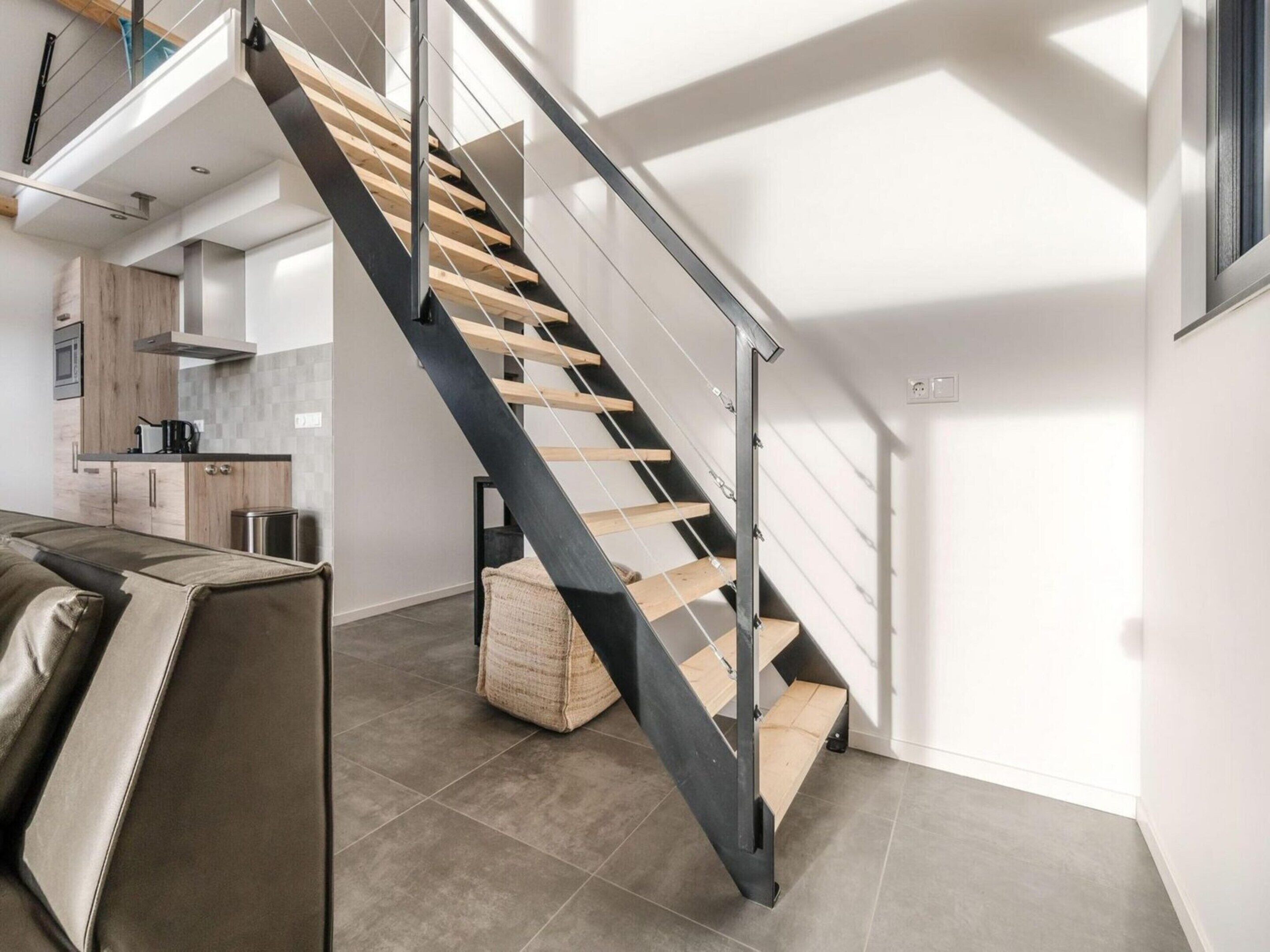 Un intérieur moderne comprenant un escalier, un coin cuisine et un espace salon.
