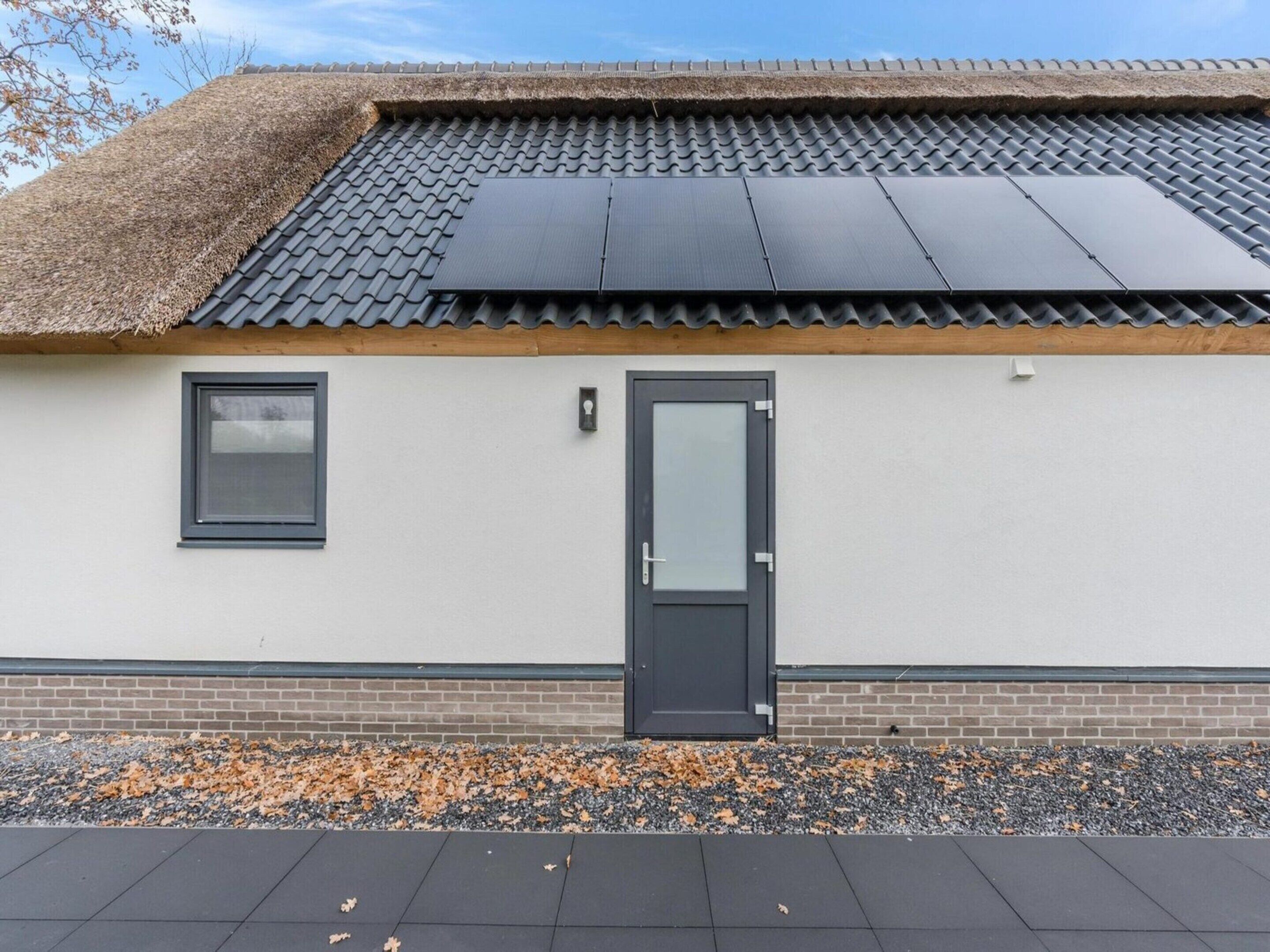 A modern building with a flat roof, a door, and a window.
