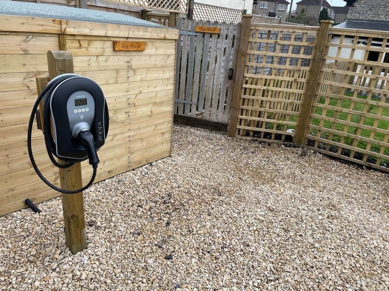 Une borne de recharge pour véhicules électriques, mobile et alimentée par l’électricité, fixée sur un poteau en bois.