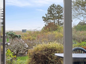 A garden with various plants and trees, a wooden fence, and a small shed. - 5 Star Holiday Home in Ebberup (Ebberup)