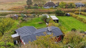 Une propriété située sur la côte, comprenant plusieurs maisons, une pelouse verdoyante et une vue sur la mer.