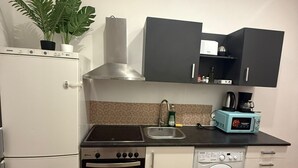 A compact kitchen with a refrigerator, oven, microwave, sink, and a washing machine. - Bright 1BR Apt Near Top Vienna Sights (Vienna)
