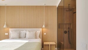 Une chambre moderne avec un grand lit, des murs recouverts de panneaux en bois et une cabine de douche en verre.