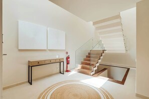 A modern interior with a staircase, a console table, and two wall-mounted artworks. - 4BR Villa w/ Private Pool | Salgados | DA’Home (Albufeira)