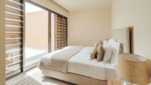 A bedroom with a bed, a nightstand, a lamp, and a sliding glass door leading to a balcony. - 4BR Villa w/ Private Pool | Salgados | DA’Home (Albufeira)
