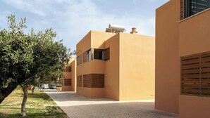 A modern building with a flat roof, a water tank on top, and a paved walkway. - 4BR Villa w/ Private Pool | Salgados | DA’Home (Albufeira)