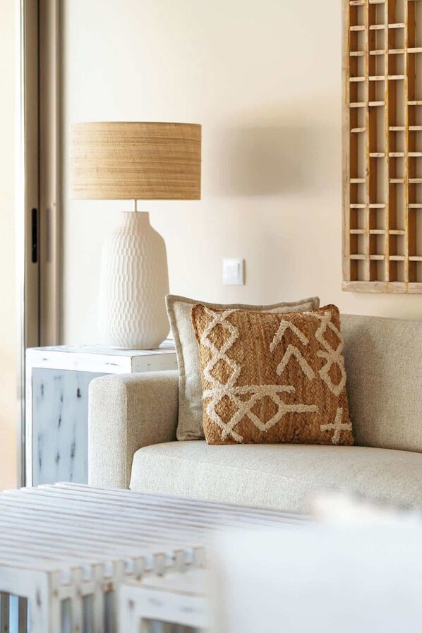 A modern living room with a sofa, a lamp, and a decorative wall panel.