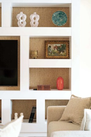 Un salon avec un téléviseur, des objets de décoration et un canapé.