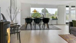 Amplia sala de estar con comedor, ventanas grandes y vista a una pagoda.