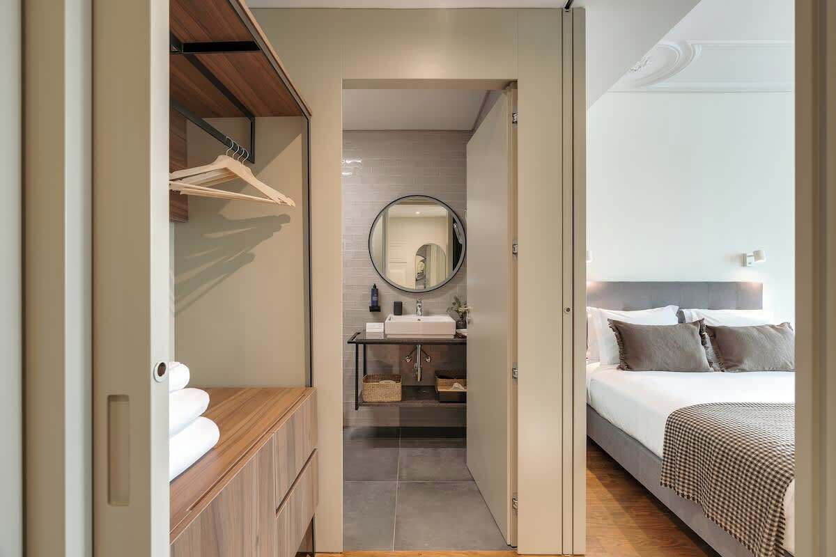 Une chambre à coucher moderne avec un grand lit, une table de chevet et un miroir.