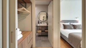 A modern bedroom with a large bed, a bedside table, and a mirror.