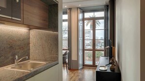 Een moderne keuken met een granieten aanrecht, een roestvrijstalen spoelbak en uitzicht op het omliggende landschap door een groot raam.