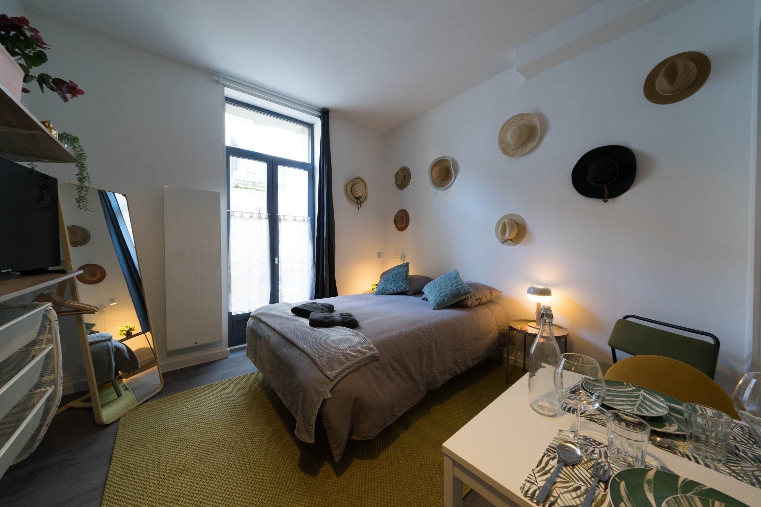 Ein modernes Schlafzimmer mit Bett, Nachttisch und einer Wand, die mit Hüten dekoriert ist.