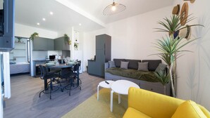A modern apartment with a dining area, kitchen, and living space. - Résidence Bardiaux - Chez Mélèze (Vichy)
