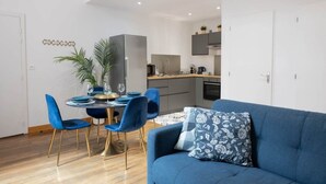 Un appartement moderne comprenant un coin repas, une cuisine et un salon.