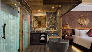A traditional Japanese-style bathroom with a stone bathtub, a wooden cabinet, and a bed with a red pillow. - Tam Coc Oasis Resort & Spa (Nam Hoa Lu)