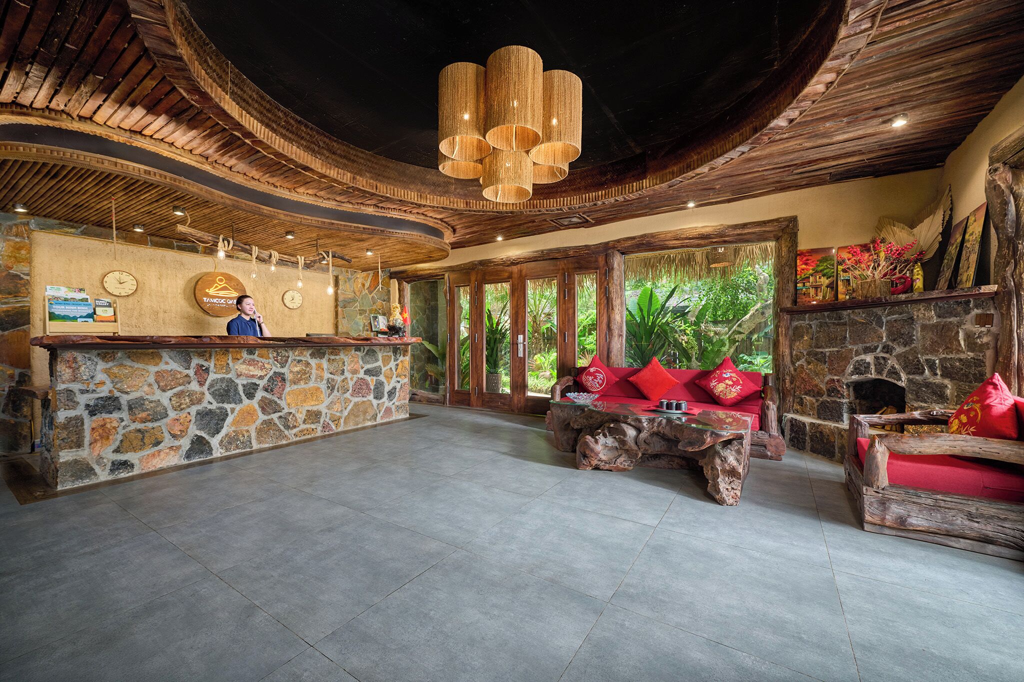 A lobby with a stone reception desk, wooden furniture, a stone fireplace, and a large wooden ceiling.