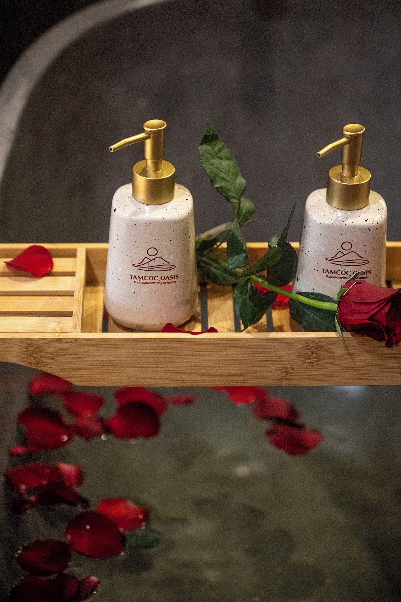 Two bottles of Tamoc Oasis soap on a wooden tray with a rose.