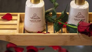 Two bottles of Tamoc Oasis soap on a wooden tray with a rose.