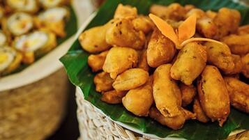 A basket of fried snacks on a banana leaf.