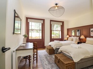 A bedroom with two beds, a desk, and a chair. There are two windows and a ceiling light fixture. - Grosvenor Abode, Royal Tunbridge Wells (Royal Tunbridge Wells)