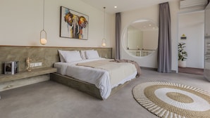 A modern bedroom with a large bed, a round mirror, and a unique wall art piece. - Villa Eudora 2br villa with private pool (Kec. Mengwi - Badung)