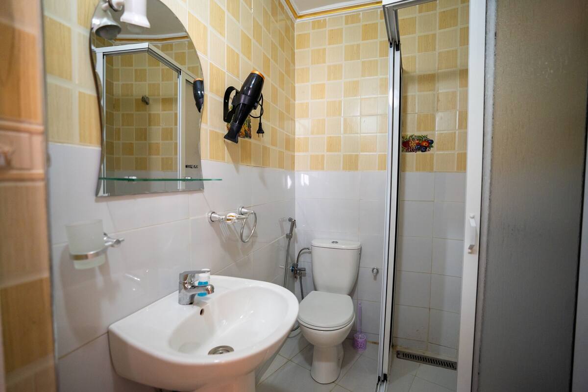 A bathroom with a sink, toilet, and shower.