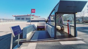 Una estación de autobuses moderna con una vista despejada del estadio SAN SIRO al fondo.